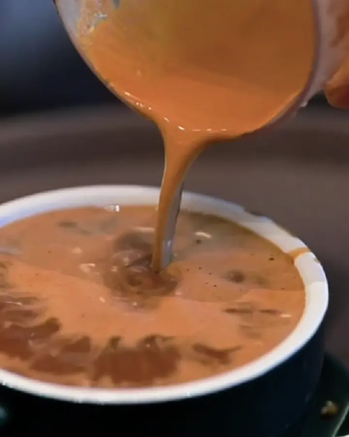 Milky kopi poured into a cup