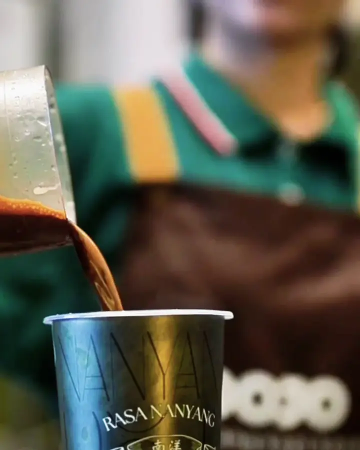 Black kopi poured over ice into a DOJO cup