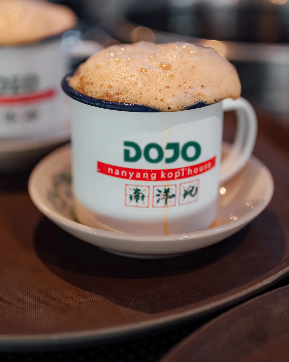 Frothy kopi in a DOJO enamel mug