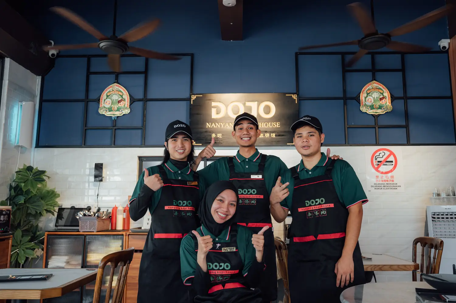 DOJO staff smiling at the counter under the DOJO sign